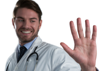 Male doctor using invisible screen against white backgroundの写真素材