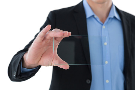 Mid section of businessman holding interface while standing against white backgroundの写真素材