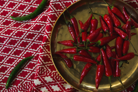 Overhead of red chilies in plate on table clothの写真素材