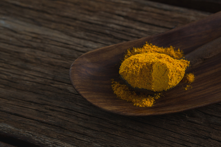 Curry powder in a bowl on wooden tableの写真素材