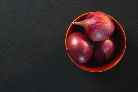 Close-up of onions in a bowl on black backgroundの写真素材