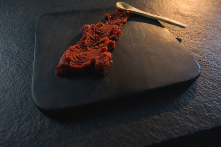 Close-up of red chili chutney on wooden boardの写真素材