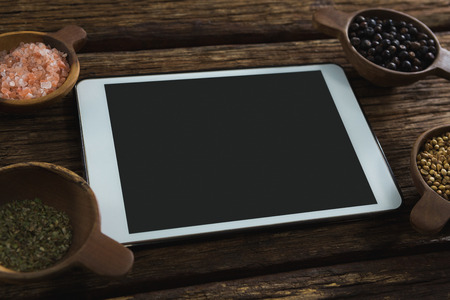 Close-up of various spices with digital tablet on wooden tableの写真素材
