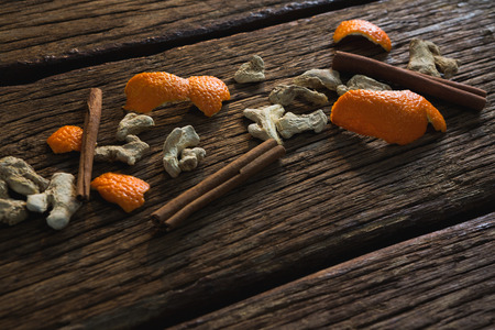Close-up of cinnamon sticks, orange peel and dried ginger on a wooden tablの写真素材
