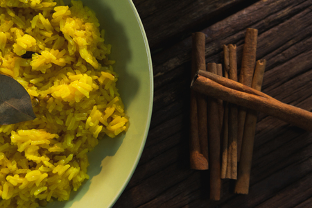Delicious food in plate with cinnamon on wooden tableの写真素材
