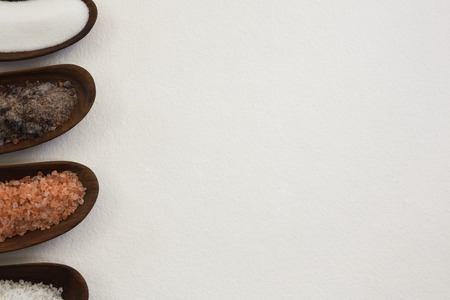 Various types of salts in a bowl against white backgroundの写真素材