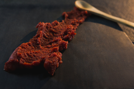 Close-up of red chili chutney on wooden board
