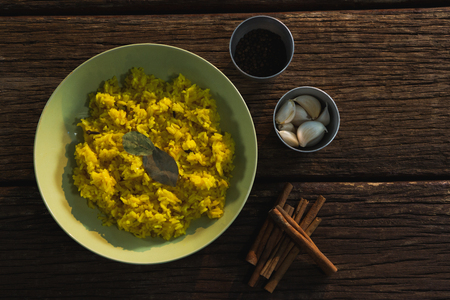 Delicious food in plate with spices on wooden tableの写真素材