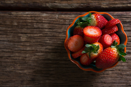 Bowl of strawberries on wooden table