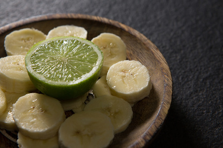 Close-up of sliced banana with halved lemon on plateの写真素材