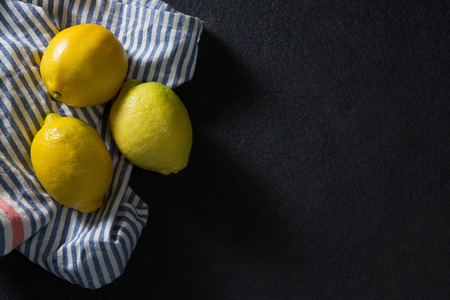 Overhead of three fresh lemons on textileの写真素材
