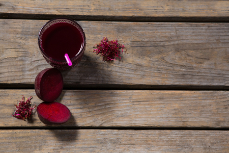 Overhead of beetroot juice and slice of beetroot on wooden tableの写真素材