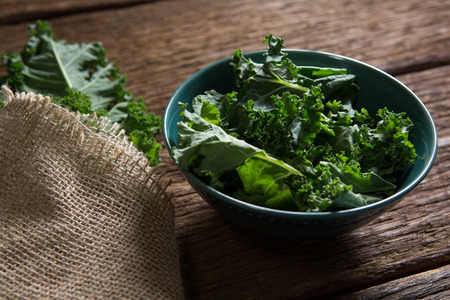 Close-up of mustard greens on wooden tableの写真素材