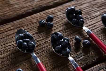 Close-up of blueberries in spoon arranged on wooden tableの写真素材