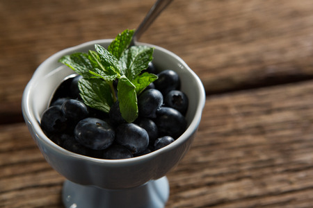 Close-up of blueberries garnished with mint in bowlの写真素材
