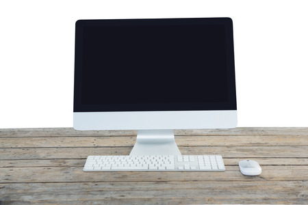 Desktop computer on wooden table against white background