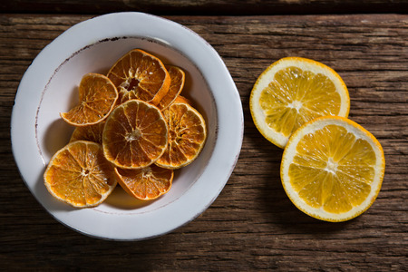Overhead of dried and sliced sweet lemon on wooden tableの写真素材
