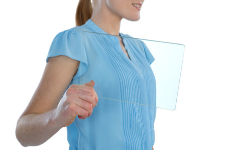 Mid section of young businesswoman showing transparent glass interface against white backgroundの写真素材