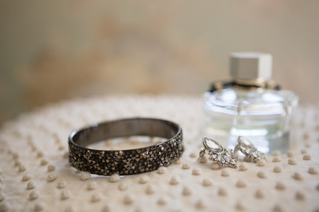 Close up of earring with bangle and perfume bottle in dressing roomの写真素材