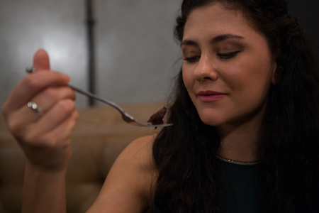 Beautiful woman having pastry in restaurantの写真素材