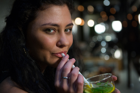 Portrait of beautiful woman drinking mocktail in restaurantの写真素材