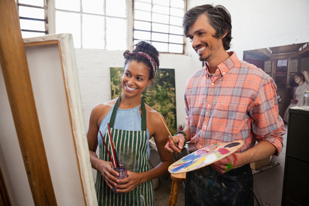 Man and woman looking at painting in drawing classの写真素材