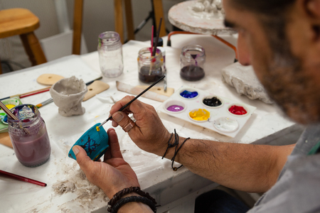 Close-up of attentive man painting bowlの写真素材