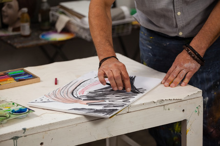 Mid section of man sketching in drawing book