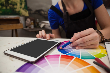 Mid section of woman matching color with color swatch at tableの写真素材