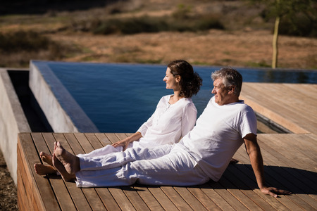Couple relaxing on wooden plank on a sunny dayの写真素材