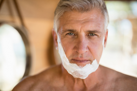 Portrait of man with shaving cream on his face during safari vacationの写真素材