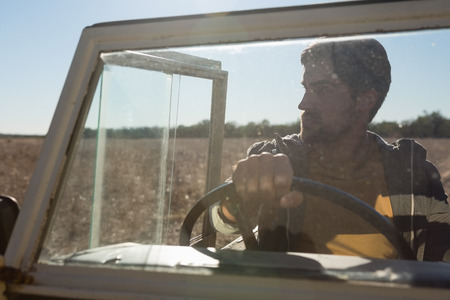 Man in off road vehicle seen through windshield at forest on sunny dayの写真素材