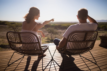 Rear view of senior couple sitting on chairs at the resortの写真素材