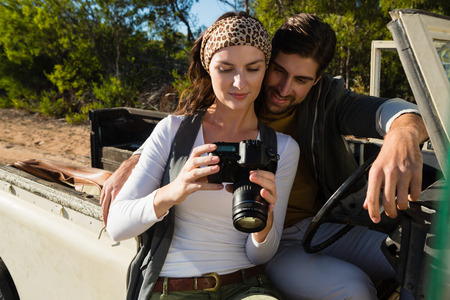 Young couple in off road vehicle looking in camera at forestの写真素材