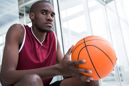 Confident player holding basketball on terraceの写真素材