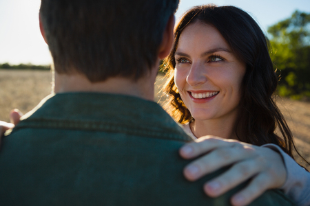 Close-up of happy young woman looking at man on fieldの写真素材
