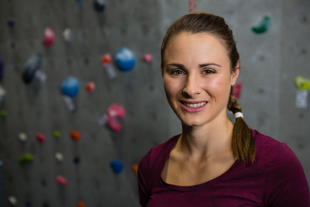 Portrait of smiling female athlete standing in gymの写真素材