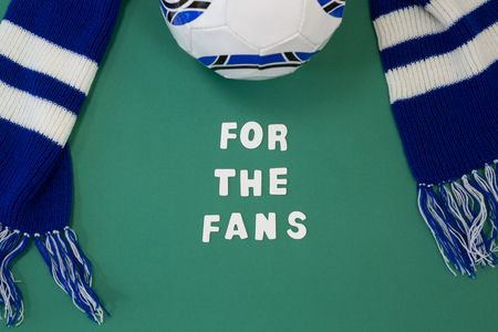 Close-up of muffler and football with text on green backgroundの写真素材