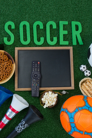 Overhead view of chalkboard, snacks and football on artificial grassの写真素材