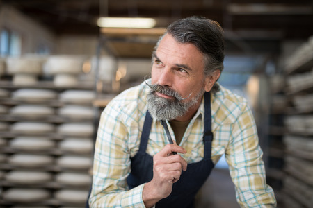 Close-up of thoughtful male potter in pottery workshop