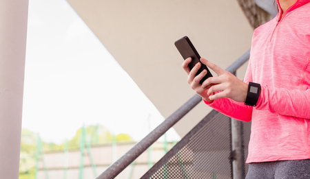 Mid-section of woman using mobile phone in staircase