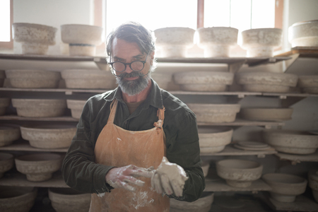 Portrait of male potter molding a clay in pottery workshopの写真素材