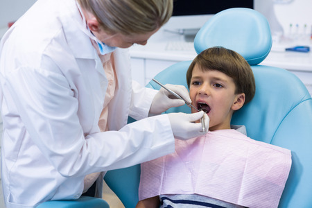 Boy receiving dental treatment by dentist at medical clinicの写真素材