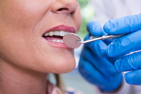 Cropped image of dentist examining woman at medical clinic