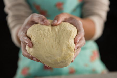 Mid-section of woman holding a doughの写真素材