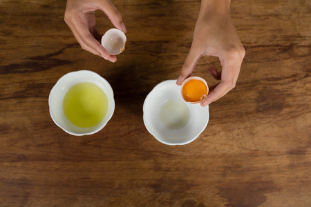 Close-up of woman holding a broken eggの写真素材