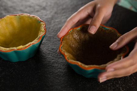 Close-up of woman holding tart dough on mold