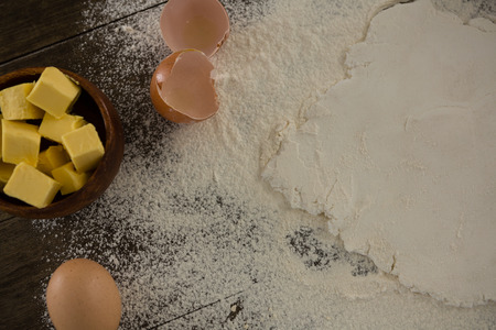 Close-up of flattened dough sprinkled with flour on a wooden tableの写真素材