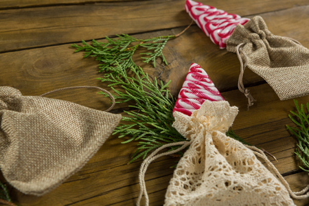 High angle view of mint candies in jute sack with pine twigs on wooden tableの写真素材