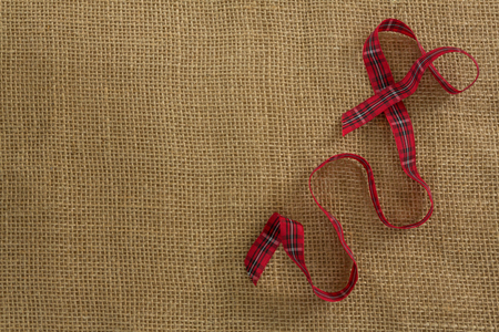 Overhead view of red ribbon on burlapの写真素材